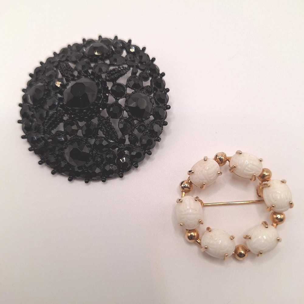 Vintage brooch pin featuring black faceted stones and carved white milk glass